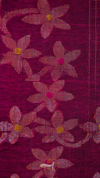 Close-up of a fabric with floral patterns on a dark red background