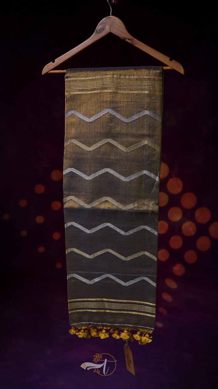 Textile with wavy pattern and yellow tassels on a hanger against a dark background