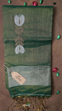 Green saree with floral patterns on a brown background