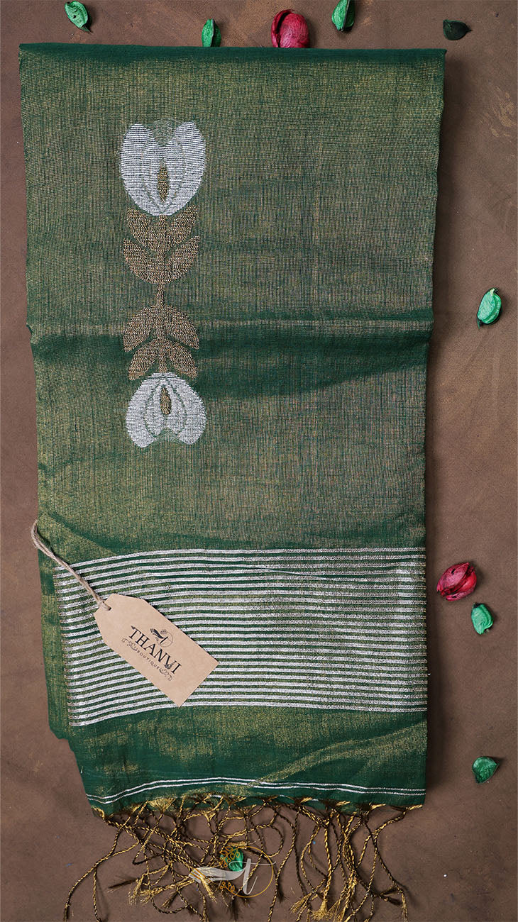 Green saree with floral patterns on a brown background