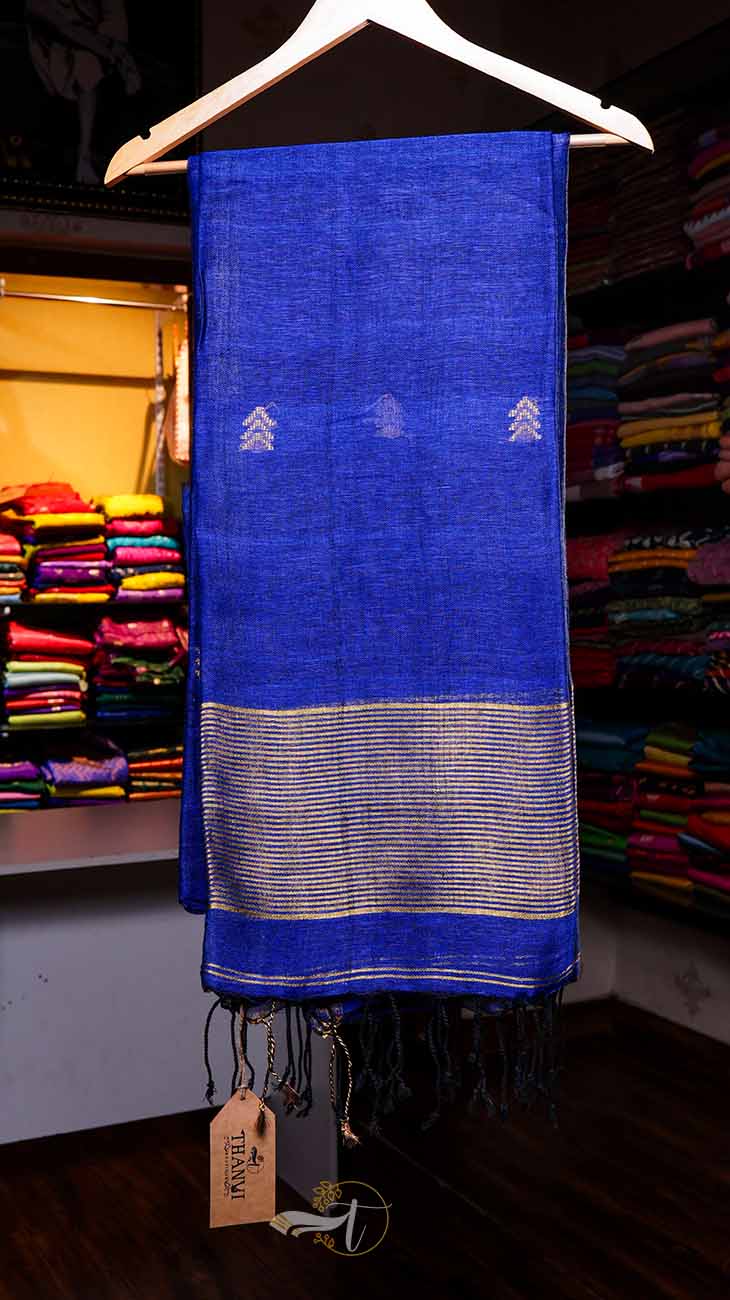 Blue scarf with white patterns on a hanger in a store setting