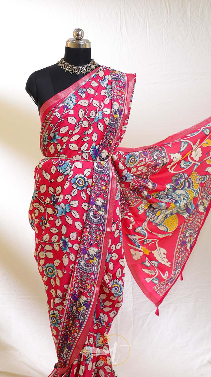 Pink saree with colorful patterns on a mannequin against a white background