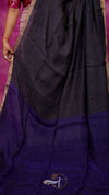 Black and purple saree with a visible brand logo on a pink background