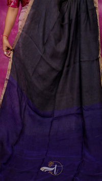 Black and purple saree with a visible brand logo on a pink background