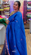 Woman wearing a blue saree with a colorful fabric background