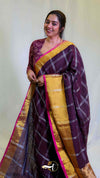 Woman wearing a traditional maroon and gold saree with a white background