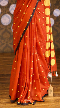 Red saree with yellow patterns on a wooden floor