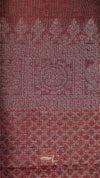 Textured fabric with a subtle pattern in shades of red and brown.