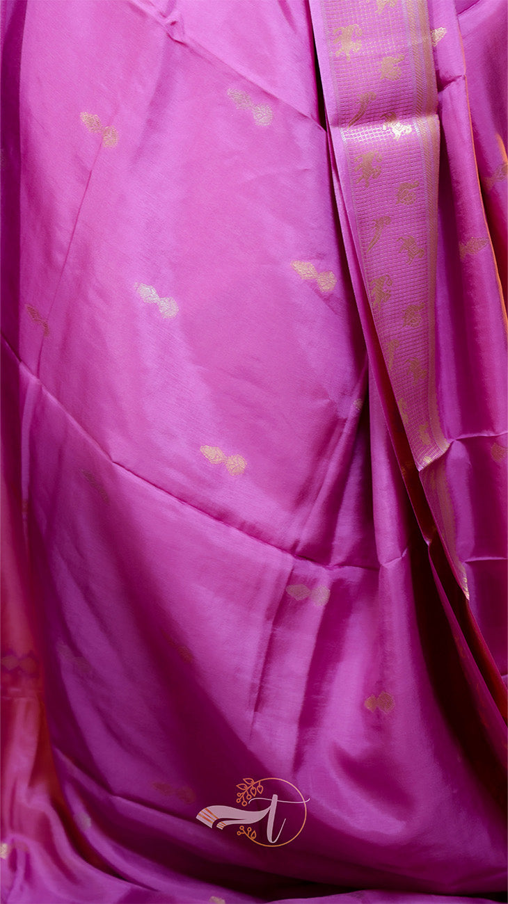 Close-up of a pink fabric with gold patterns and a brand logo.