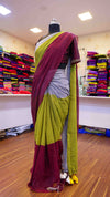 Mannequin wearing a maroon and green saree in a store setting with colorful fabrics in the background.