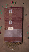 Brown fabric with embroidered design and a visible brand tag on a brown background