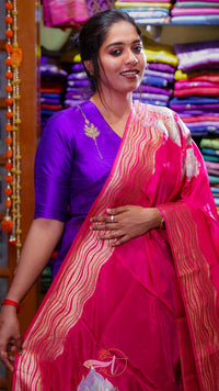 Woman wearing a purple blouse and pink saree with a colorful background