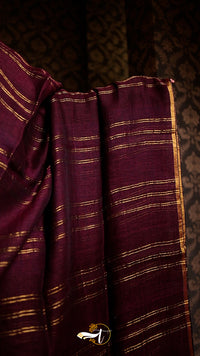 Close-up of purple fabric with gold stripes against a dark background