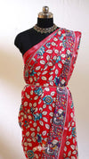 Red saree with floral patterns on a mannequin against a white background