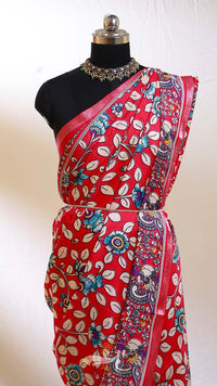 Red saree with floral patterns on a mannequin against a white background