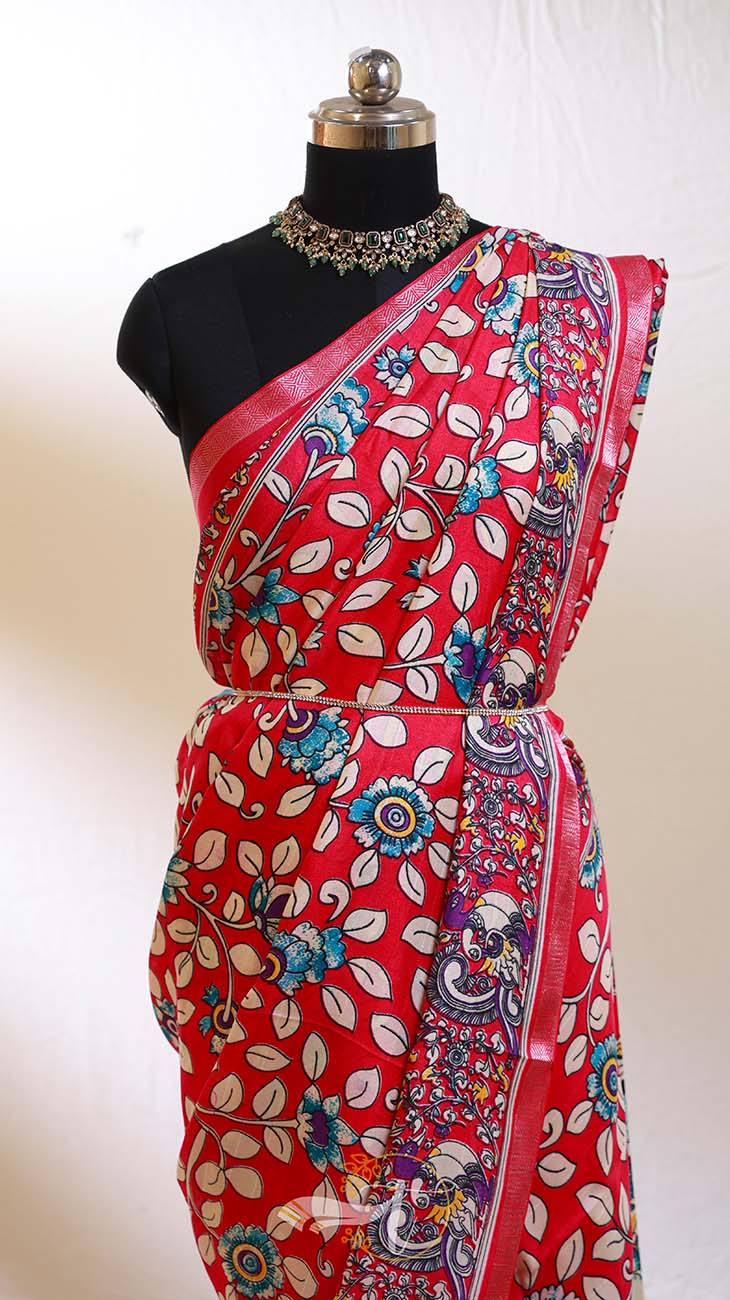 Red saree with floral patterns on a mannequin against a white background