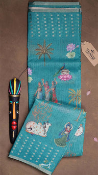 Teal fabric with embroidered designs on a brown surface, featuring a tag labeled 'Timmee'.