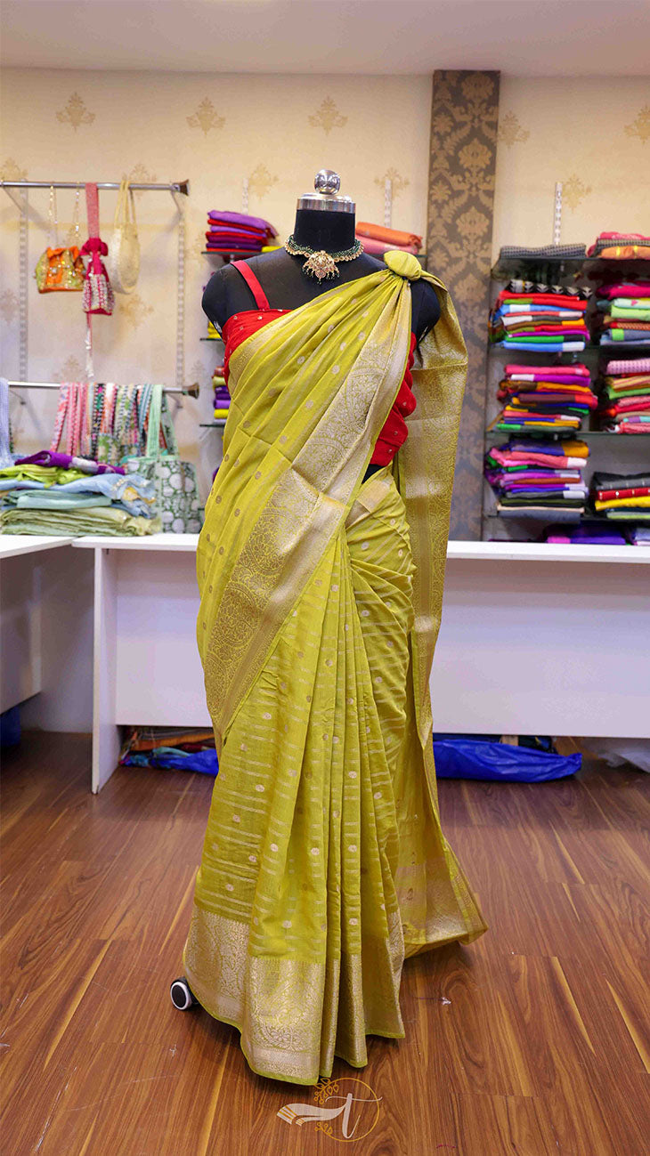 Mannequin wearing a yellow saree with a red blouse in a store setting.