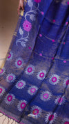 Blue fabric with floral patterns and a hand holding it