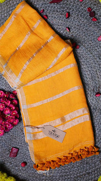 Yellow towel with white stripes and a tag on a textured surface with pink flowers.