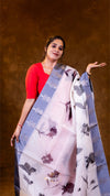 Woman holding a floral saree against a brown background