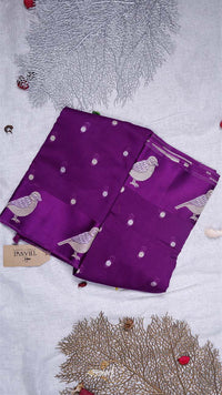 Purple fabric with bird patterns on a textured surface
