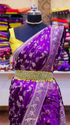 Purple saree with yellow blouse on a mannequin against a colorful fabric background