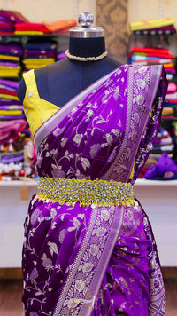 Purple saree with yellow blouse on a mannequin against a colorful fabric background