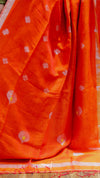Orange fabric with white floral patterns on a wooden surface