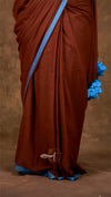 Brown saree with blue border and floral ends on a brown background