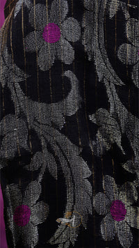 Close-up of a floral patterned fabric with black, gray, and purple colors.