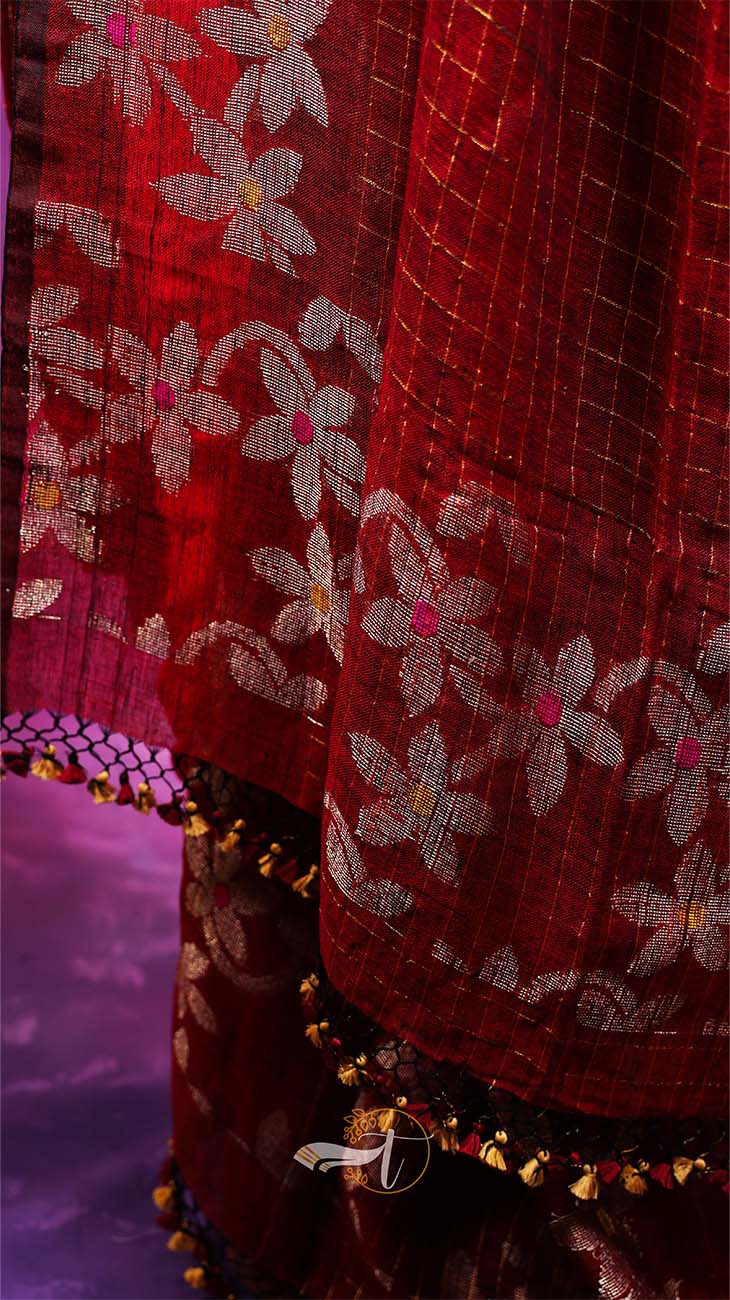 Close-up of a red fabric with floral patterns and decorative elements.