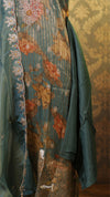 Embroidered garment with floral patterns on a textured wall background