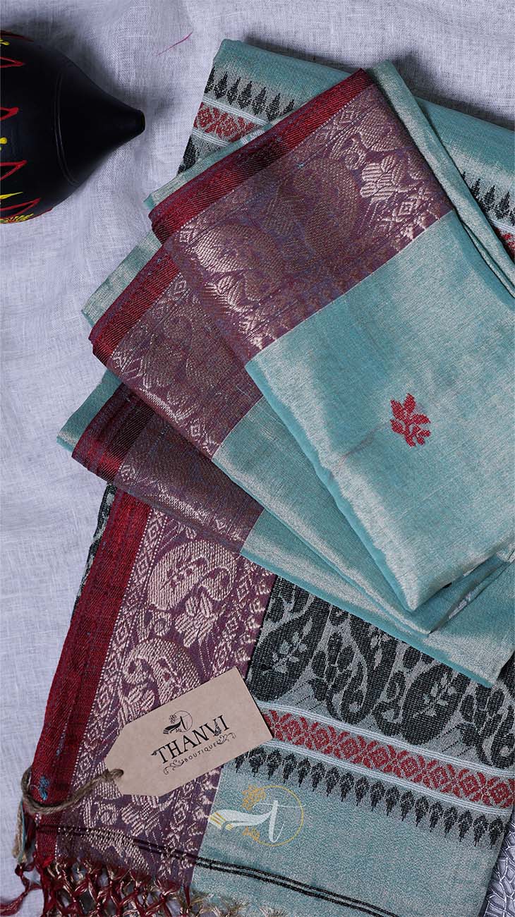 Stack of patterned cloths with a 'THANX' tag on a textured surface