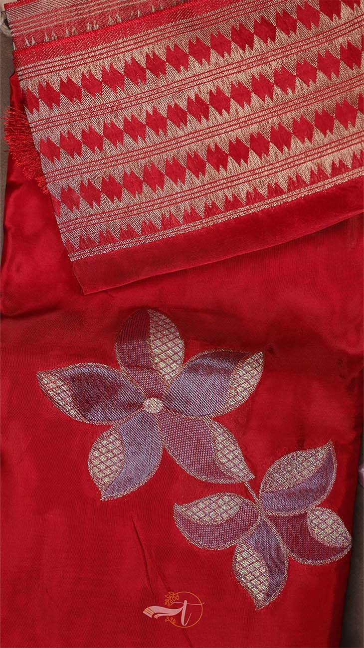 Red fabric with embroidered flowers and patterned border