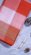 Red and pink checkered fabric with a woven pattern on a textured surface.