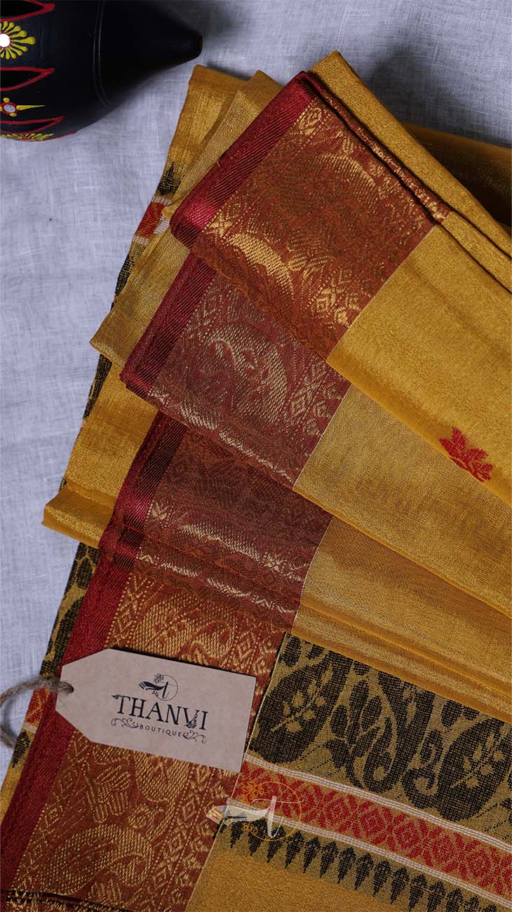 Stack of patterned fabric with a 'THANVI' tag on a textured surface