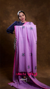 Woman wearing a purple embroidered scarf with tassels on a brown background