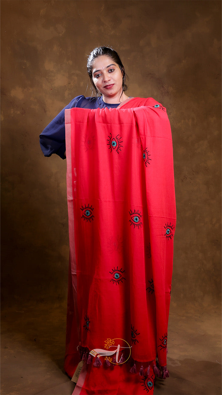 Woman holding a large red scarf with black patterns against a brown background