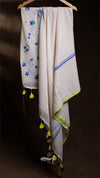 White scarf with floral embroidery and tassels on a dark background