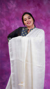 Woman wearing a white saree with a purple background