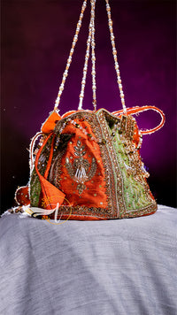 Decorative handbag with intricate designs on a purple background