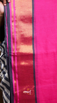 Close-up of a pink fabric with black and orange stripes, featuring a brand logo.