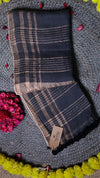 Plaid scarf with a brand tag on a textured surface with flowers