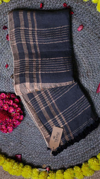 Plaid scarf with a brand tag on a textured surface with flowers