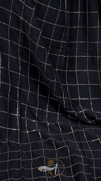 Close-up of a black checkered fabric with a small logo on a dark background