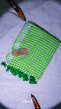 Green checkered towel with tassels on a light gray background