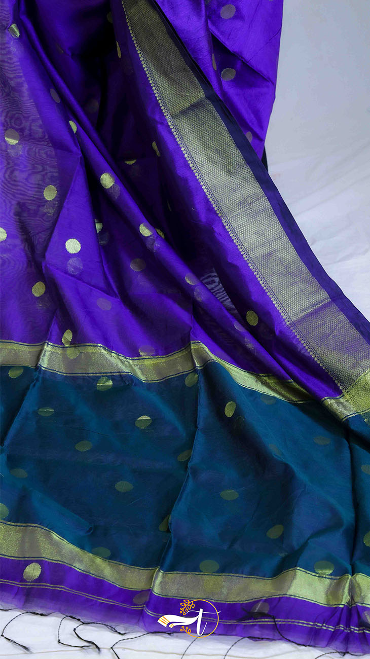 Purple and blue saree with gold border on a white background