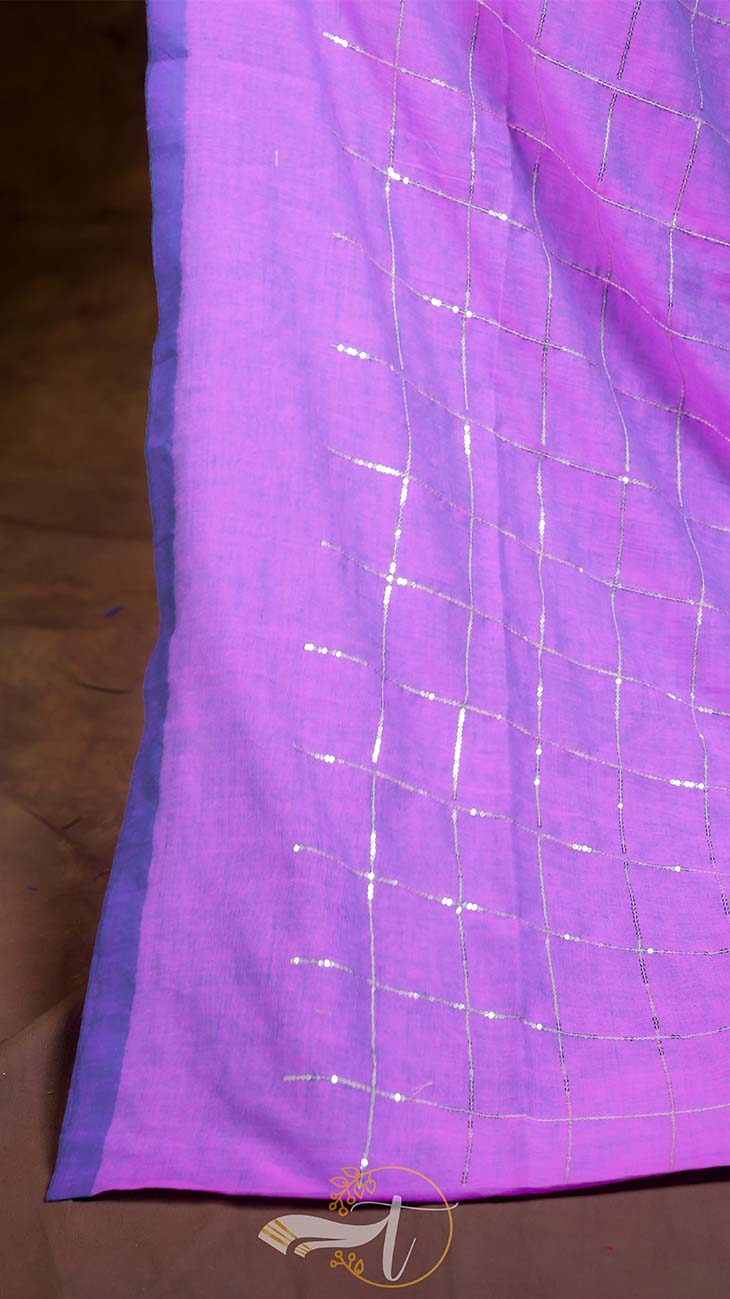 Close-up of purple fabric with silver grid pattern on a brown surface