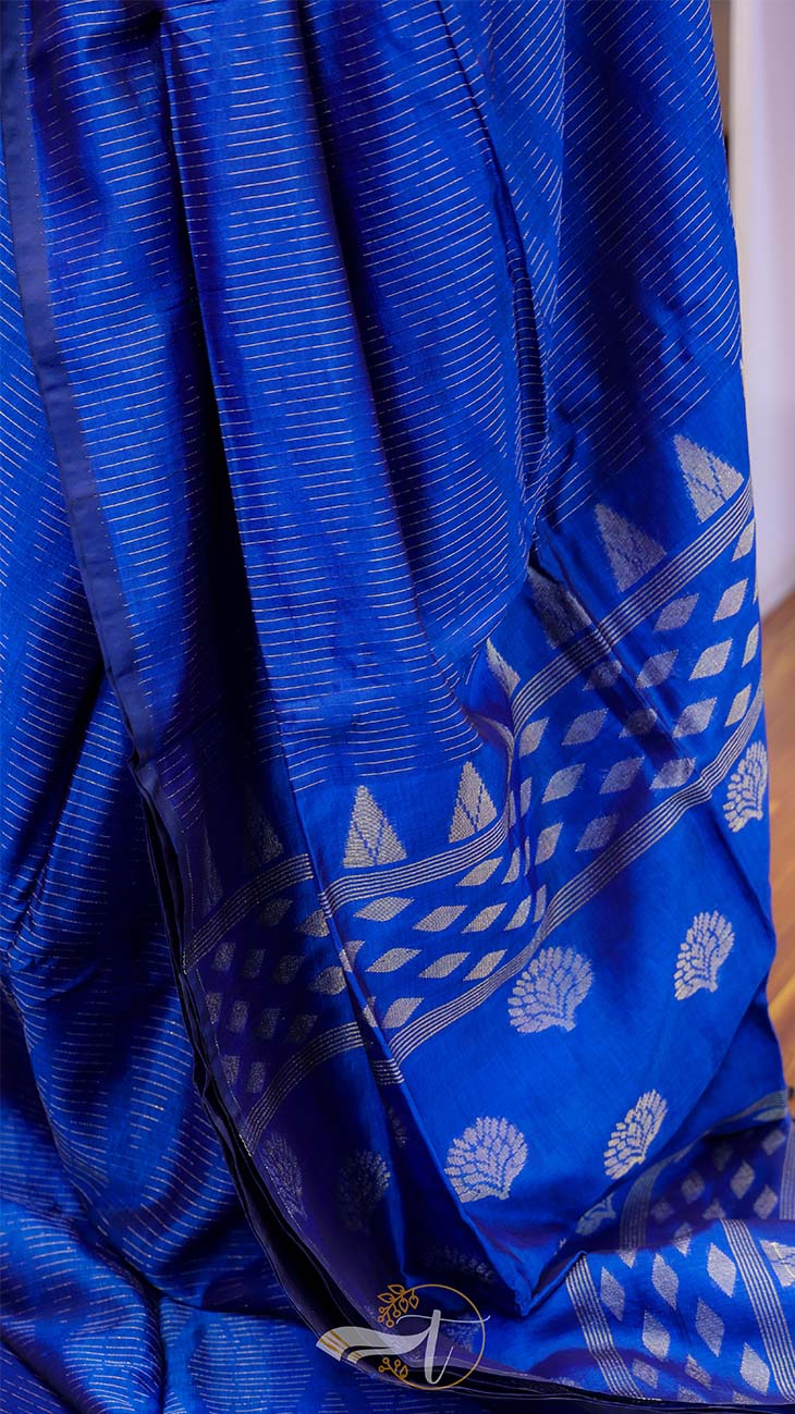 Blue fabric with white patterns, possibly a sari or a similar garment.